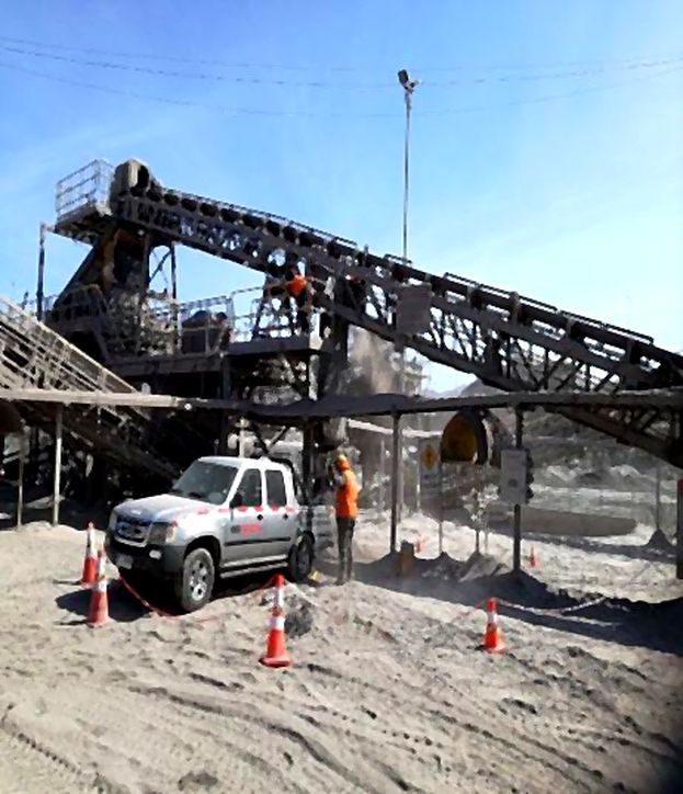 Estructura de correa transportadora con área de trabajo señalizada mediante conos