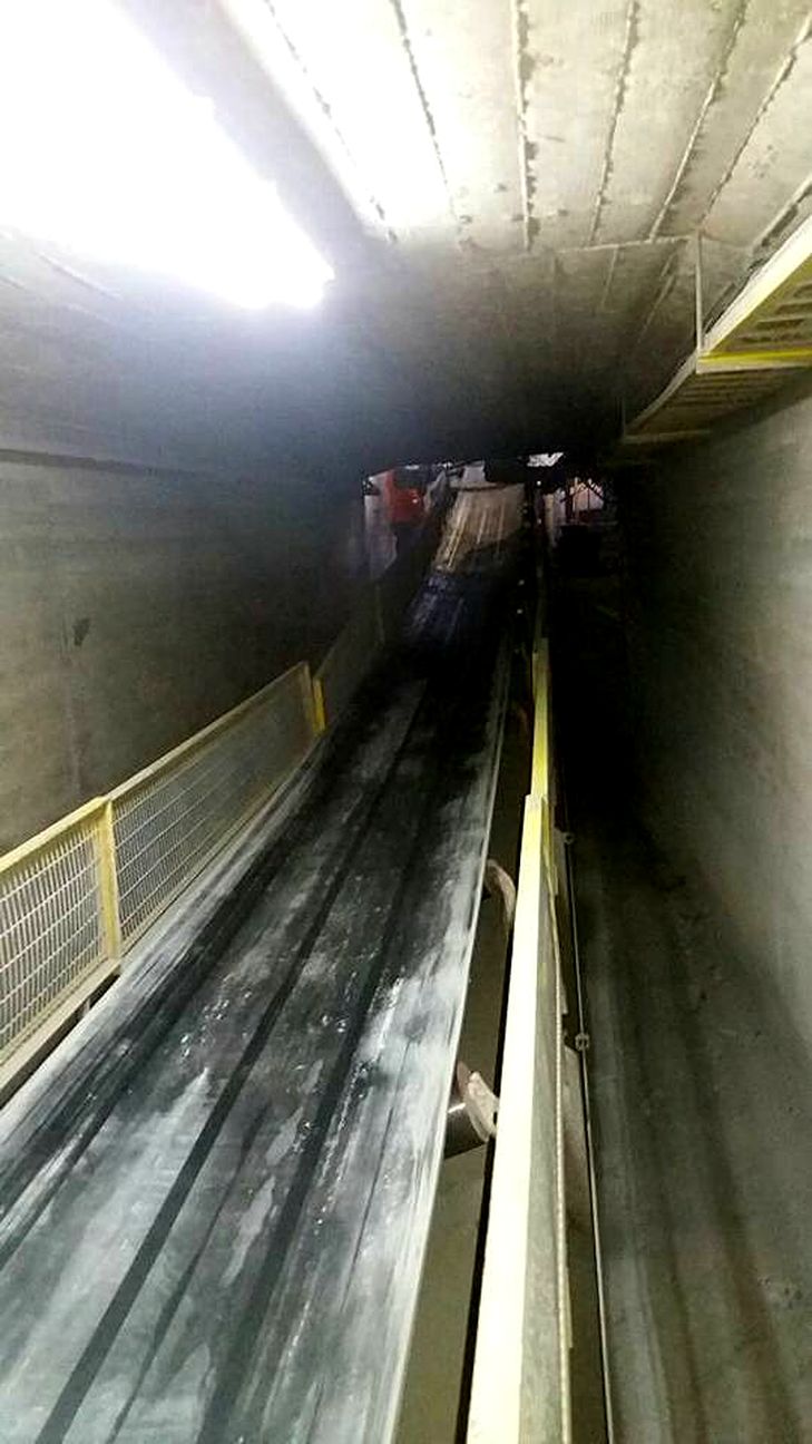 Correa transportadora en galería subterránea iluminada